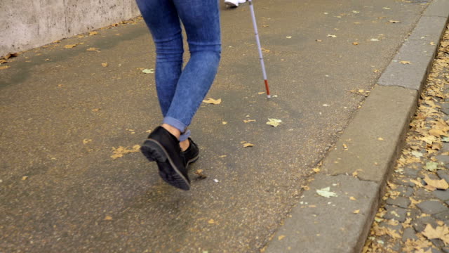 close-up-on-Blind-person-walking-on-sidewalk-with-stick.Handicap,-autonomy,-independence