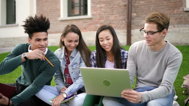Mixed-race-students-look-through-the-laptop-watching-on-screen-information-online