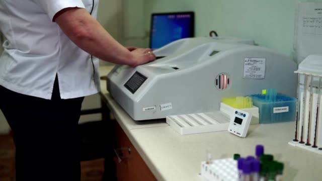Die-Labortechnikerin-richtet-eine-Labormaschine-für-die-Blutanalyse-ein.-Moderne-Medizintechnik.