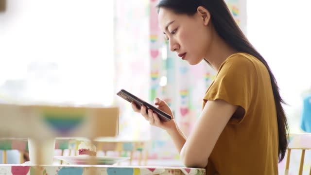 Handheld-view-of-young-woman-enjoying-wireless-internet-at-cafe