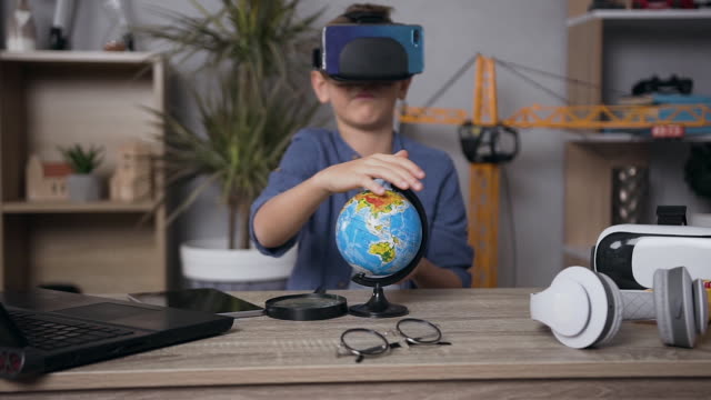 Ansprechende-moderne-ernsthafte-Teenager-Junge-trägt-Virtual-Reality-Headset-und-Telefon-Studing-die-Struktur-der-Globus
