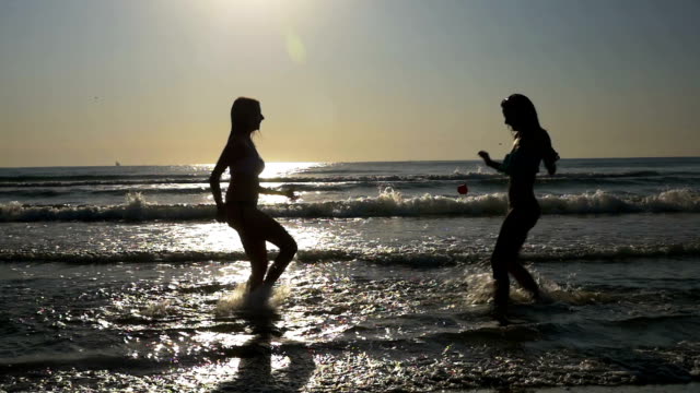 Freundinnen-spielen-im-Wasser-am-Ufer-des-Meeres-in-Zeitlupe