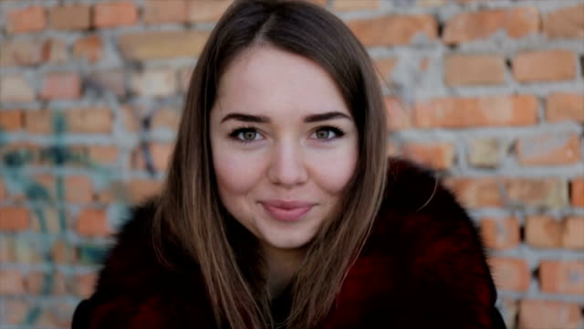 Portrait-of-a-cute-girl-on-the-brick-wall-background.Full-hd-video