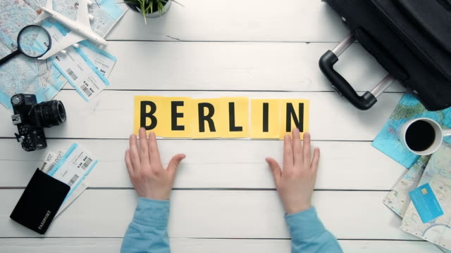 Top-view-time-lapse-hands-laying-on-white-desk-word-""-decorated-with-travel