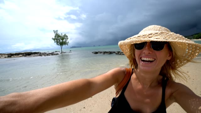 Girl-taking-selfie-portrait-on-tropical-beach-in-Thailand