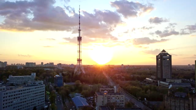 A-bird's-eye-view-video-from-the-drone-in-FullHD-to-the-Kyiv-TV-Tower-and-Kyiv-TV-Center-in-the-city-Kiev,-Ukraine.-Pedestal-up-slow-video-against-a-bright-sun,-at-summer.