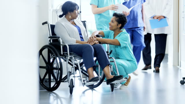 Multi-ethnischen-Team-und-ältere-Patienten-im-Rollstuhl