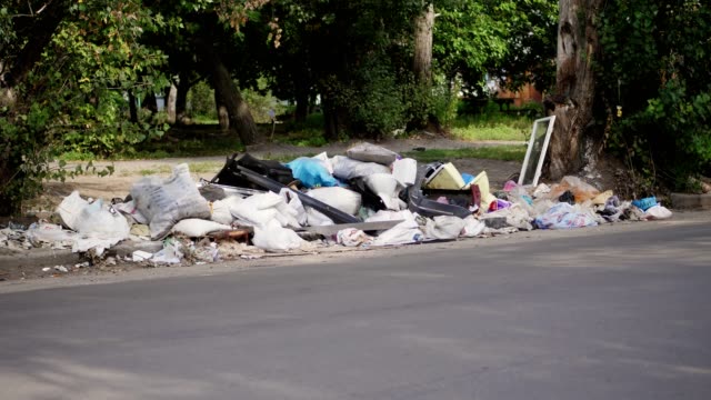 en-terreno,-a-lado-de-carretera,-un-montón-de-basura-es-mentira.-dispersa-la-basura,-basura,-cosas-viejas,-neumáticos-coche,-roto-el-vidrio,-plástico.-botadero-de-basura.-Ecología,-contaminación-del-medio-ambiente