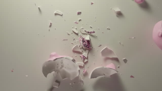 TOP-VIEW:-Pink-pig-money-box-falls-on-a-table-and-breaks-on-a-pieces---Slow-motion