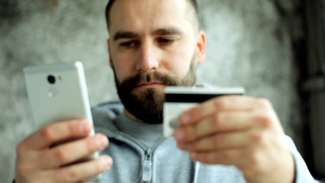 Hombre-banca-en-línea-utilizando-el-teléfono-inteligente-de-compras-en-línea-con-tarjeta-de-crédito