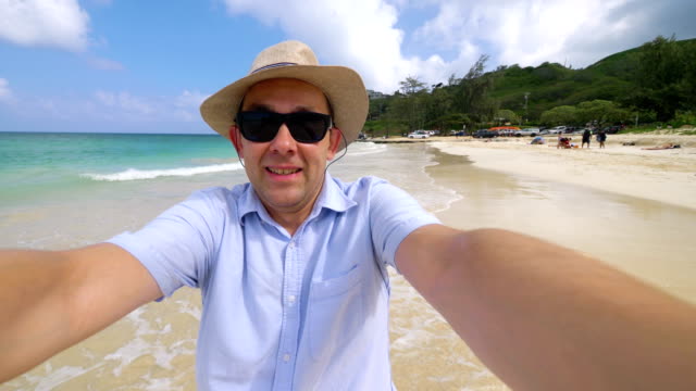 Happy-man-taking-a-selfie-in-Hawaiian-beach-in-4k-slow-motion--60fps