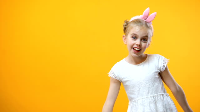 Kleine-Mädchen-spielen-mit-farbigen-Ostern-Eier-gelben-Hintergrund-Kindheit-begeistert