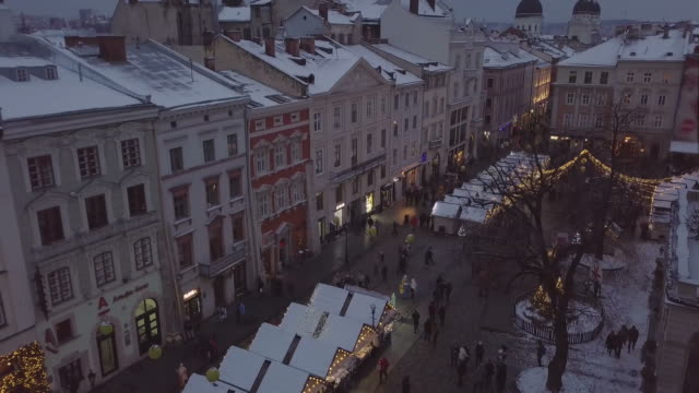 Lviv,-Ucrania---25-de-diciembre-de-2018.-Tiro-de-Arial.-Invierno.-Calle-plaza-Rynok.-Feria-de-Navidad.-Ayuntamiento-de-Lvov,-Consejo-de-la-ciudad.-Personas-están-caminando-en-el-centro-de-la-ciudad.-Adornos-navideños-y-luces.-Noche