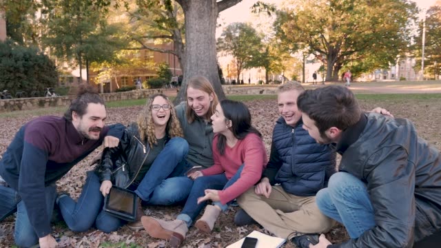Close-group-of-college-friends-hanging-outside-with-their-smart-phones