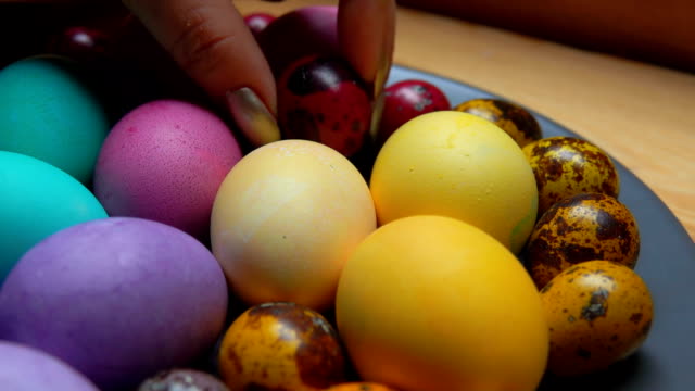 Woman's-hand-laid-red-and-green-colored-quail-egg
