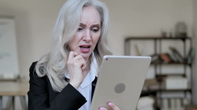 Traurige-alte-Geschäftsfrau-reagiert-auf-Verlust-auf-Smartphone