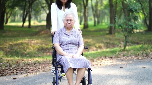 Hilfe-und-Pflege-asiatische-ältere-oder-ältere-alte-Frau-Patientin-sitzt-auf-dem-Rollstuhl-in-der-Krankenpflegestelle:-Gesundes-starkes-medizinisches-Konzept