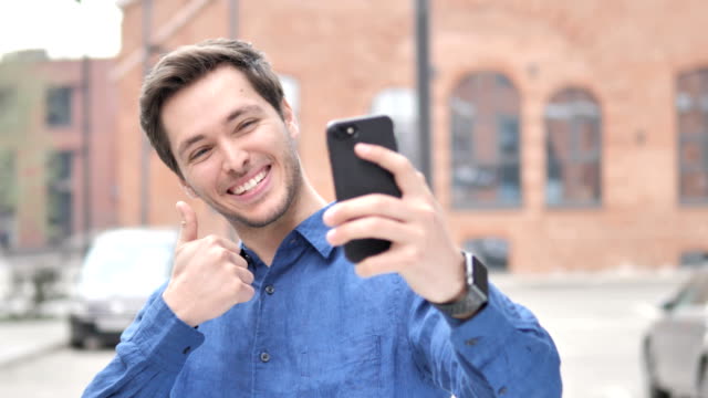 Outdoor-Porträt-von-jugendlichen-Mann-nimmt-Selfie-auf-Telefon