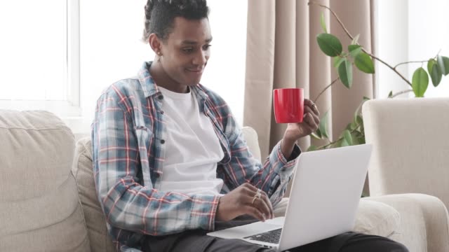 Man-having-coffee-and-using-laptop-at-home