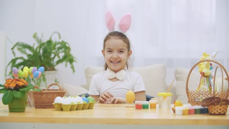 Little-cute-and-adorable-girl,-with-a-beauty-spots-on-the-face-is-smiling-sincerely.-Girl-is-showing-her-flats-of-the-hands,-then-touching-a-fluffy-tie-bow-and-dressing-it-on-the-her-pretty-face,-Playful-girl.