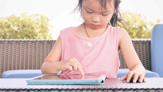 Chica-asiática-feliz-usando-tableta-inteligente-en-la-mesa,-concepto-de-estilo-de-vida.