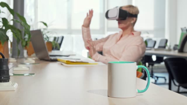 Empresaria-femenina-usando-gafas-de-realidad-virtual-3D-en-la-oficina