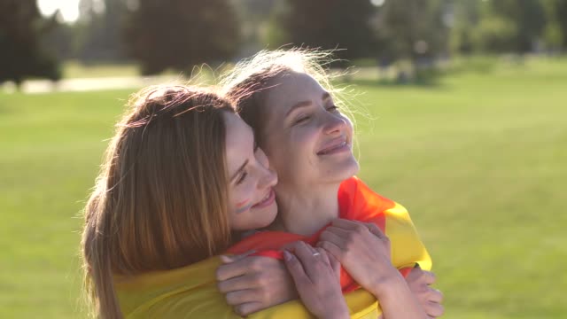 Retrato-de-pareja-lesbiana-alegre-abrazándose-en-el-parque