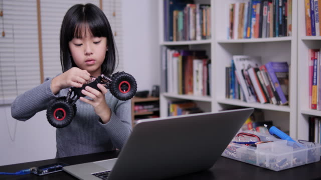 Kleines-Mädchen-versucht,-Roboter-in-der-Schule-allein-zu-machen.-Mädchen-mit-Talent-und-sie-versuchen,-Roboter-selbst-zu-beheben.-Technologie--und-Bildungskonzept.