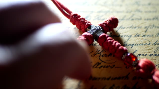 Fingerklopfen-auf-alten-Brief-und-christliches-Kreuz
