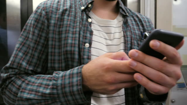 Man-using-mobile-phone-in-a-subway-train