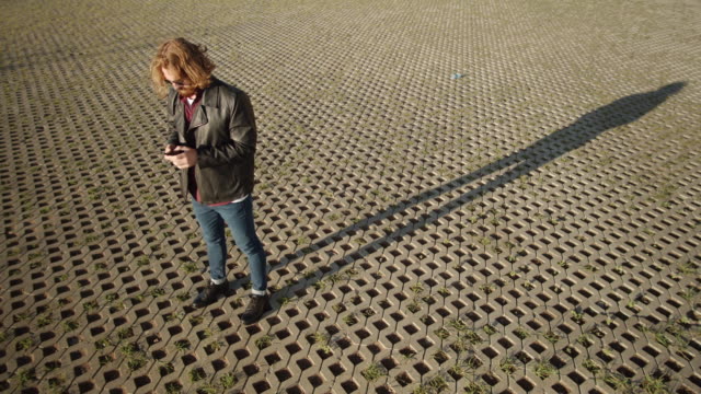 Junge-stilvolle-Ingwer-Mann-mit-Smartphone-im-Freien