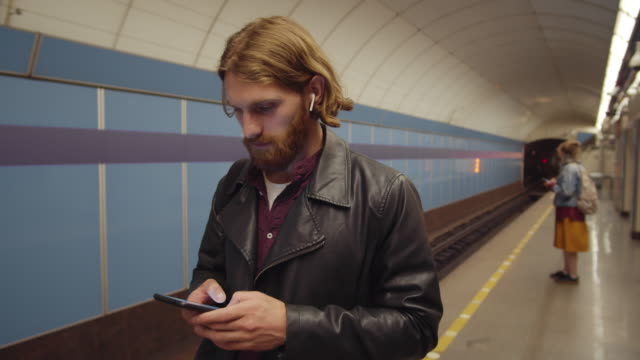Red-haired-Man-Using-Phone-at-Subway-Station