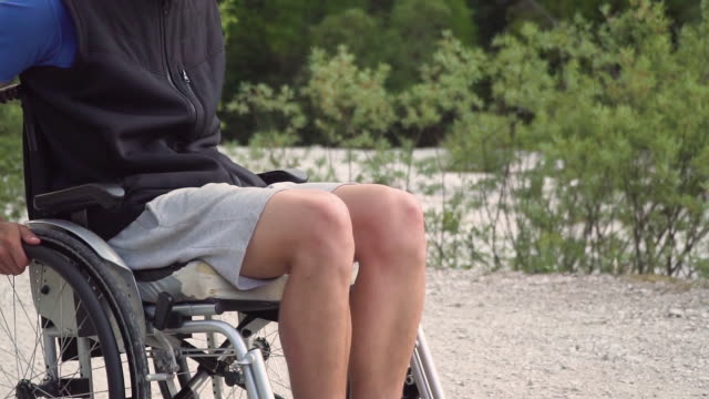 Slowmotion-closeup-of-disabled-young-student-man-in-a-wheelchair