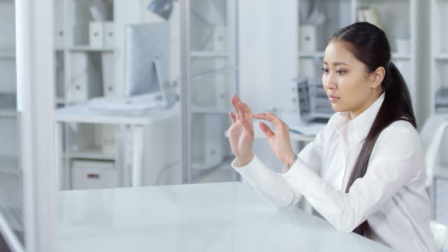 Weibliche-asiatische-Büroarbeiterin-mit-unsichtbarem-AR-Touchscreen-Gerät