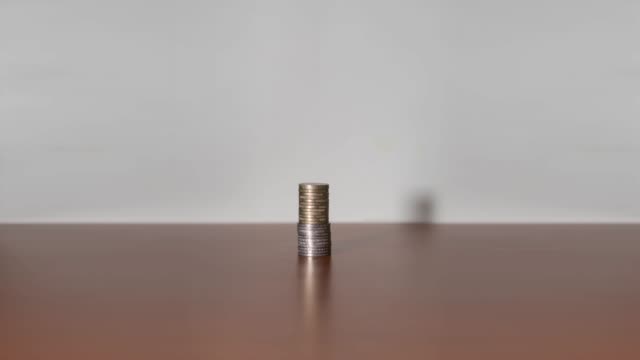 Coins-in-stop-motion-increase-upwards-on-a-piece-of-furniture