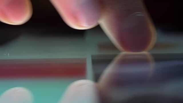 Close-up-Macro-Man-Browsing-Tablet-Computer-With-Finger.-Person-Using-Smartphone,-Browsing-through-Pictures-on-Social-Network-Wall.-Close-Up-Finger-Scrolling-Social-Media-App-Feed.