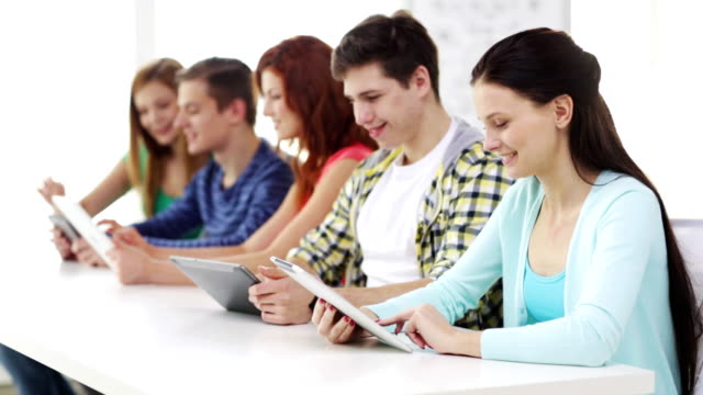 glückliche-Schüler-mit-Tablet-PCs-in-der-Schule-lernen