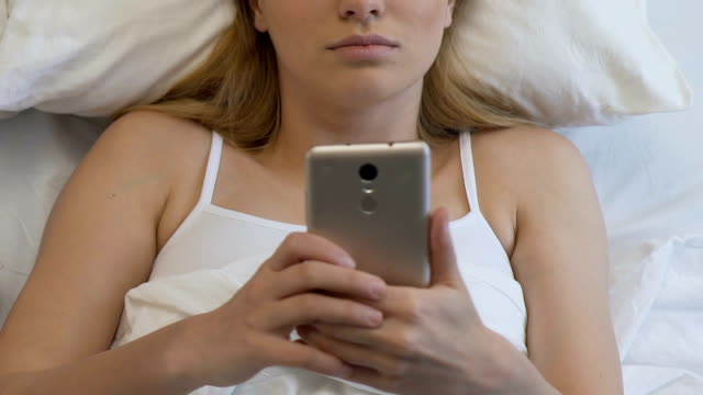Schüler-weiblich-mit-Smartphone-im-Bett,-chatten-in-sozialen-Netzwerken-bis-zum-Morgen