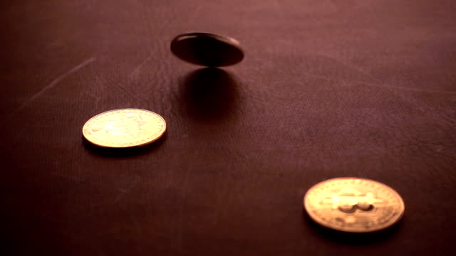 bit-coin--spinning-in-slow-motion-on-leather-top-table-background