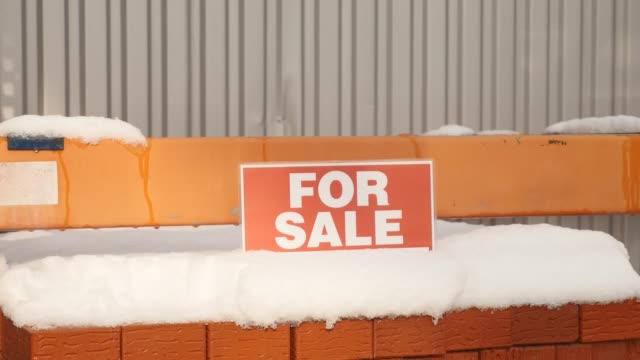 Pila-de-ladrillos-de-arcilla-naranja-con-nieve-"en-venta"-palabras