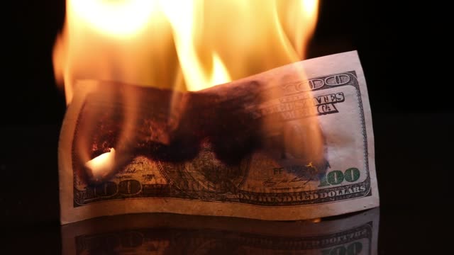Dollar-bill-in-flames.-American-money-burning-on-black-background.