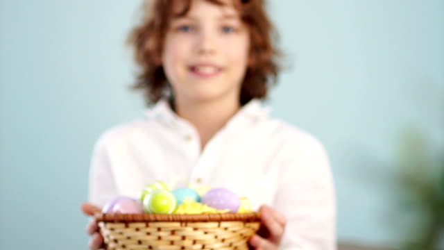 Clouse-up-ap-portrait-of-a-curly-red-haired-boy-with-a-basket-of-Easter-eggs-in-his-hands.-Happy-easter