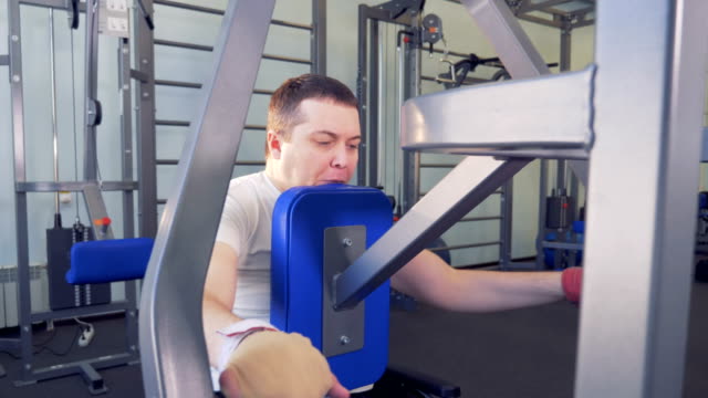 Man-in-wheelchair-overcomes-himself-in-doing-exercises-in-gym.