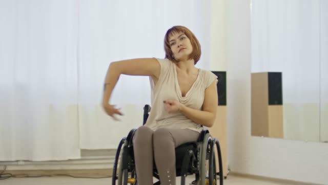 Mujer-en-silla-de-ruedas-bailando-y-hablando-con-el-coreógrafo