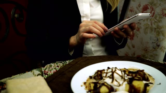 Señora-de-negocios-en-el-restaurante-ver-fotos-con-smartphone