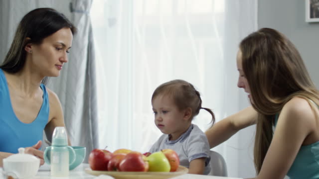 Female-Couple-Giving-Breakfast-to-Toddler