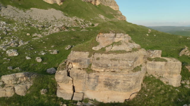 Flying-around-a-large-rock-formation-standing-at-the-foot-of-the-epic-edge-of-a-rocky-plateau.-Russia.-North-Caucasus