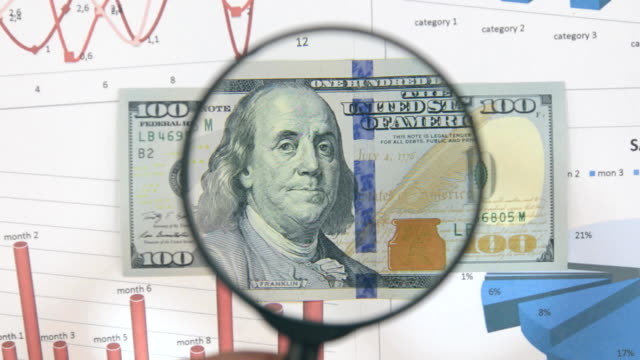Studie-einer-Banknote-in-100-US-Dollar,-mit-Hilfe-einer-Lupe-erhöhen.
