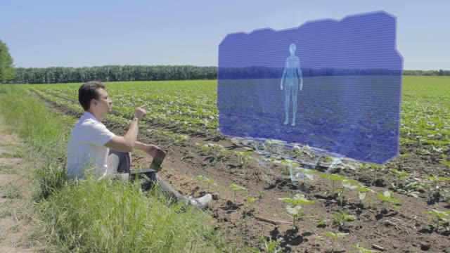Hombre-está-trabajando-con-mujer-3D-en-pantalla-holográfica-en-el-borde-del-campo