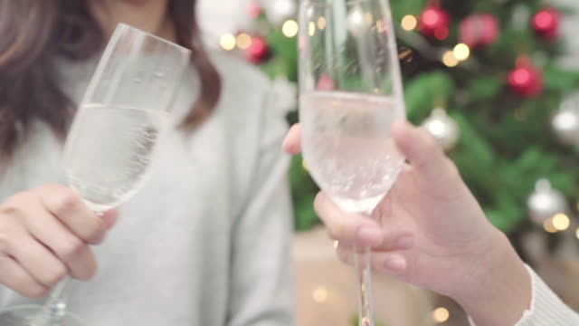 Group-of-cheerful-happy-young-Asian-woman-holding-and-drinking-glasses-of-champagne-in-christmas-party-at-home.-Lifestyle-women-celebrate-Christmas-and-New-year-concept.